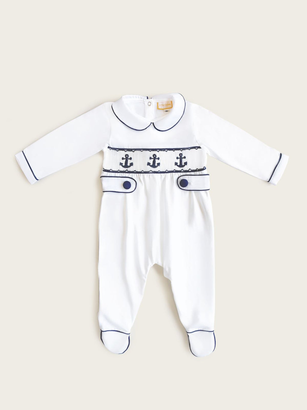 Little Collins Clothing white babygrow with smocking, peter pan collar and blue anchors front far view