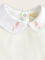 A close up on the ballerinas embroidered onto the collar of the classic pique bodysuit in white.