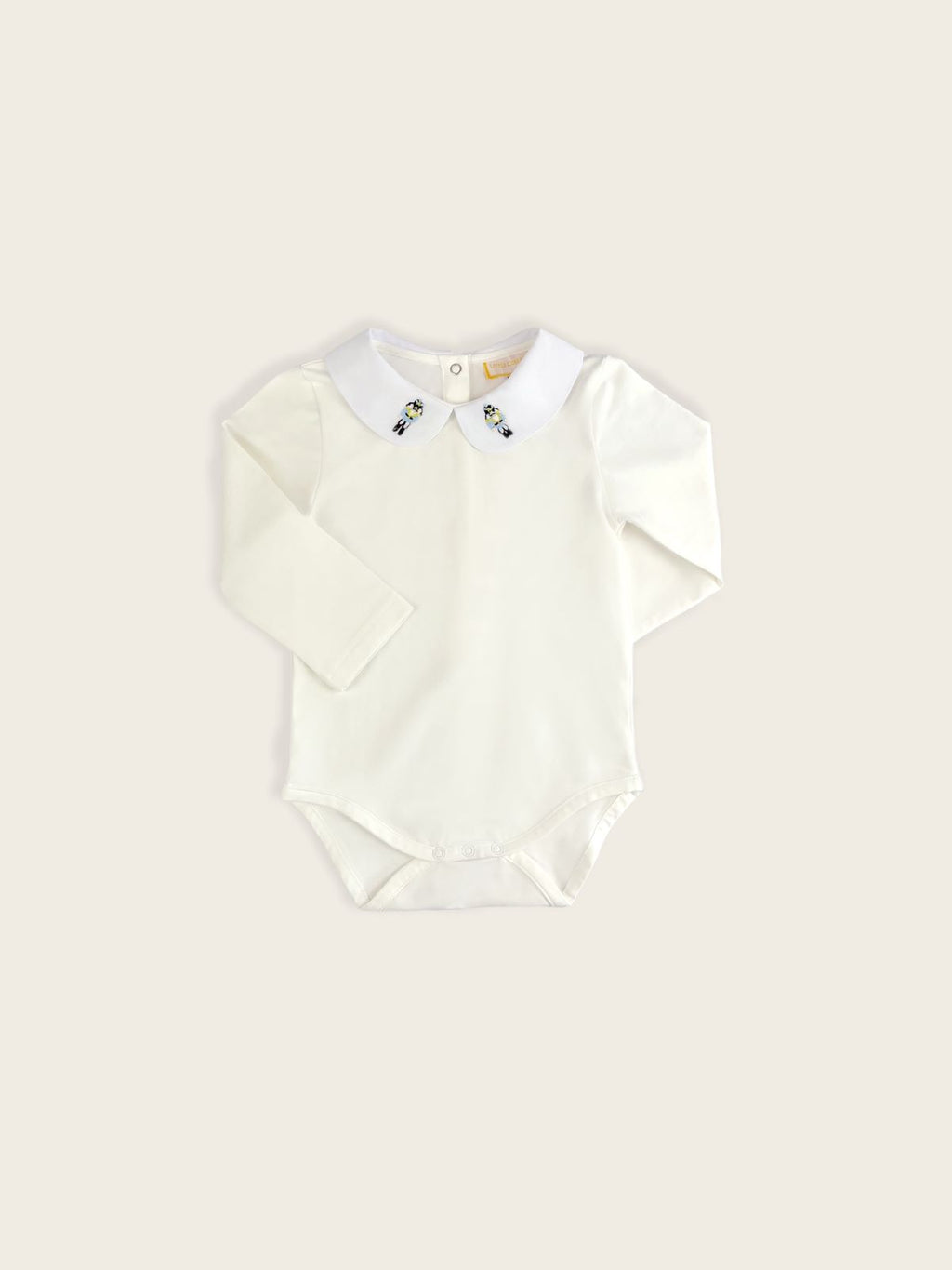 A classic pique bodysuit in white with a Danish soldiers embroidered onto the collar.