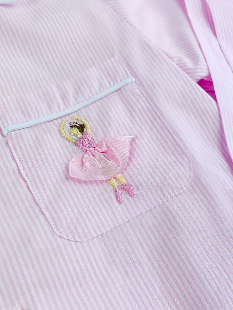 Close up of the ballerina embroidered onto the front pocket of the pink and white striped long sleeve pyjamas.