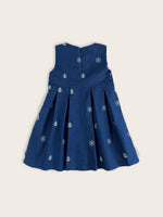 Blue nautical denim girls dress featuring white embroidered anchor and ships wheel motifs rear view